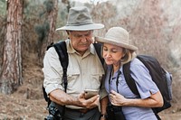 Senior partners using their smartphone in the forest 