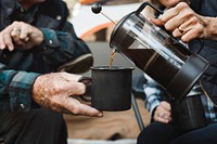 Happy senior couple having coffee by the tent in the forest