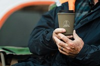 Senior man holding green reusable cup