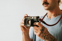 Photographer with tattoos shooting with a film camera