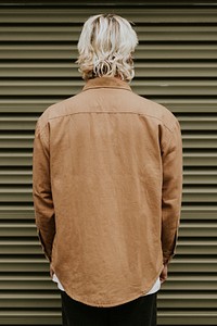 Blonde man in brown shirt jacket with design space rear view