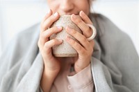 Woman taking a sip of tea from the mug during winter