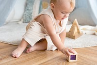 Baby girl playing with a wooden block