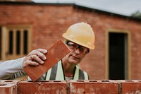 Woman contactor laying bricks outside the home