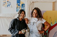 Woman artists posing together in their art studio