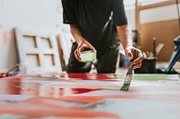 Woman artist working on her paint canvas in her studio 