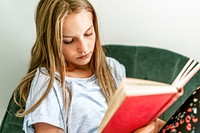 Young girl reading a book on a couch, new normal hobby