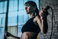 Sporty woman exercising by jump rope at the gym 