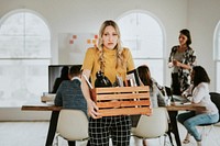 Young businesswoman carrying a wooden box 