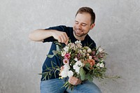 Happy man rearranging the bouquet of flowers