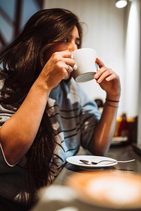 Woman sitting in a cafe sipping coffee
