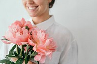 Happy woman holding a bouquet of peonies