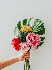 Woman holding up a tropical flower bouquet