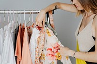 Woman in a yellow dress organizing a dress on a garment rack