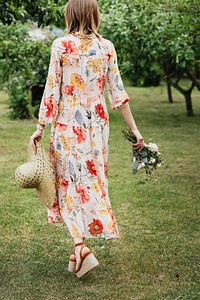 Woman in a floral dress walking in a garden