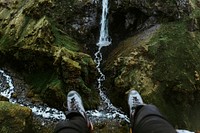 Pair of legs with a view of a waterfall