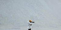 Photographer on a green hill at the Stokksnes peninsula in Southeast Iceland