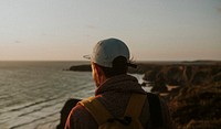 Man watching the sunset from a cliff