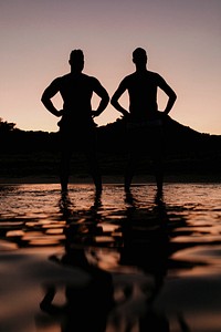 men standing at the beach in the evening silhouette