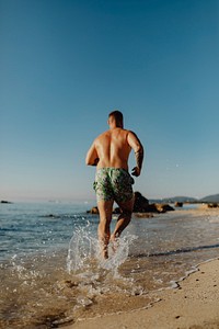 Rearview of man jogging alone the beach