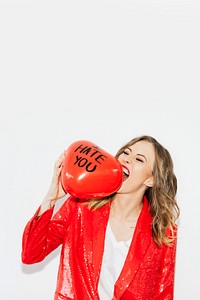 Woman in red jacket biting a red balloon with I Hate You text