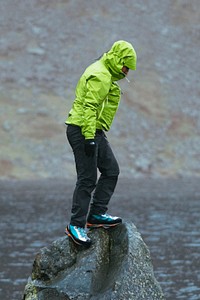 Woman standing on a slipperys rock under the rain