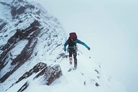 Mountaineer using an ice axe to climb Forcan Ridge in Glen Shiel, Scotland