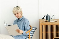 Asian woman siting on a chair reading a book