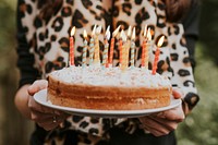 Woman bringing a birthday cake to her birthday friend