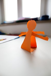 Orange stick figure shaped paper cut out