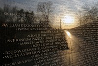 Early morning photograph of the Vietnam Memorial Wall with the reflection of the Washington Monument.