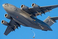 Paratroopers assigned to the 4th Infantry Brigade Combat Team (Airborne), 25th Infantry Division, U.S. Army Alaska, jump from an Air Force C-17 Globemaster III with the 517th Airlift Squadron during airborne training over Malemute drop zone, Joint Base Elmendorf-Richardson, Alaska, Jan. 9, 2018. The Soldiers of 4/25 belong to the only American airborne brigade in the Pacific and are trained to execute airborne maneuvers in extreme cold weather/high altitude environments in support of combat, training and disaster relief operations. (U.S. Air Force photo by Alejandro Peña). Original public domain image from Flickr