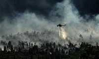 A helicopter drops water on the fire as firefighters continued to battle the blaze that burned into the evening hours in Waldo Canyon on the U.S. Air Force Academy June 27, 2012.