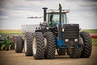 A tractor on the Auer Farm near Broadview, Mont., pulls a no-till drill. Yellowstone County, Montana. June 2017.. Original public domain image from Flickr