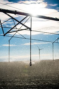 In irrigation pivot on a field in Burley, Idaho with wind turbines in the background. Near W 500 S and S 400 W streets. 10/8/2018 Photo by Kirsten Strough. Original public domain image from Flickr