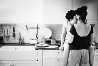 Lesbian couple hugging in kitchen