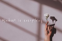 Mindset is everything quote on a hand holding flower background