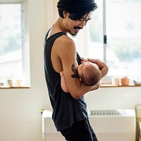 Happy Asian dad holding his baby in his arms