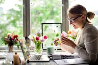 Woman smelling a flower in the office 