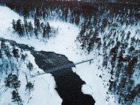 Bridge across melting ice flowing through the woods