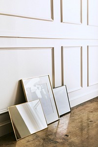 Blank frame  by a white wall