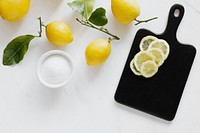 Fresh slices of lemon on a black chopping board flatlay