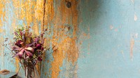 Bouquet of dry flowers by a grunge blue wall