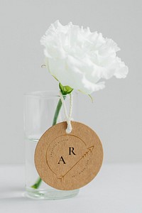 White peony in a cleared vase with a tag