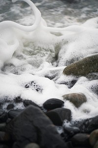 Foamy wave on a rocky shore at Isle of Skye, Scotland