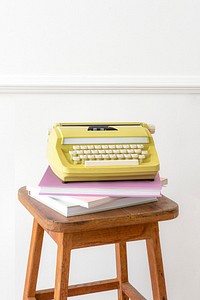 Vintage yellow typewriter on a wooden stool 