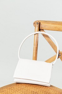 White handbag on a wooden chair