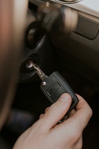 Hand holding car key to start