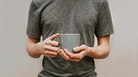 Man holding a gray ceramic coffee cup