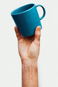 Hand holding a blue ceramic coffee cup